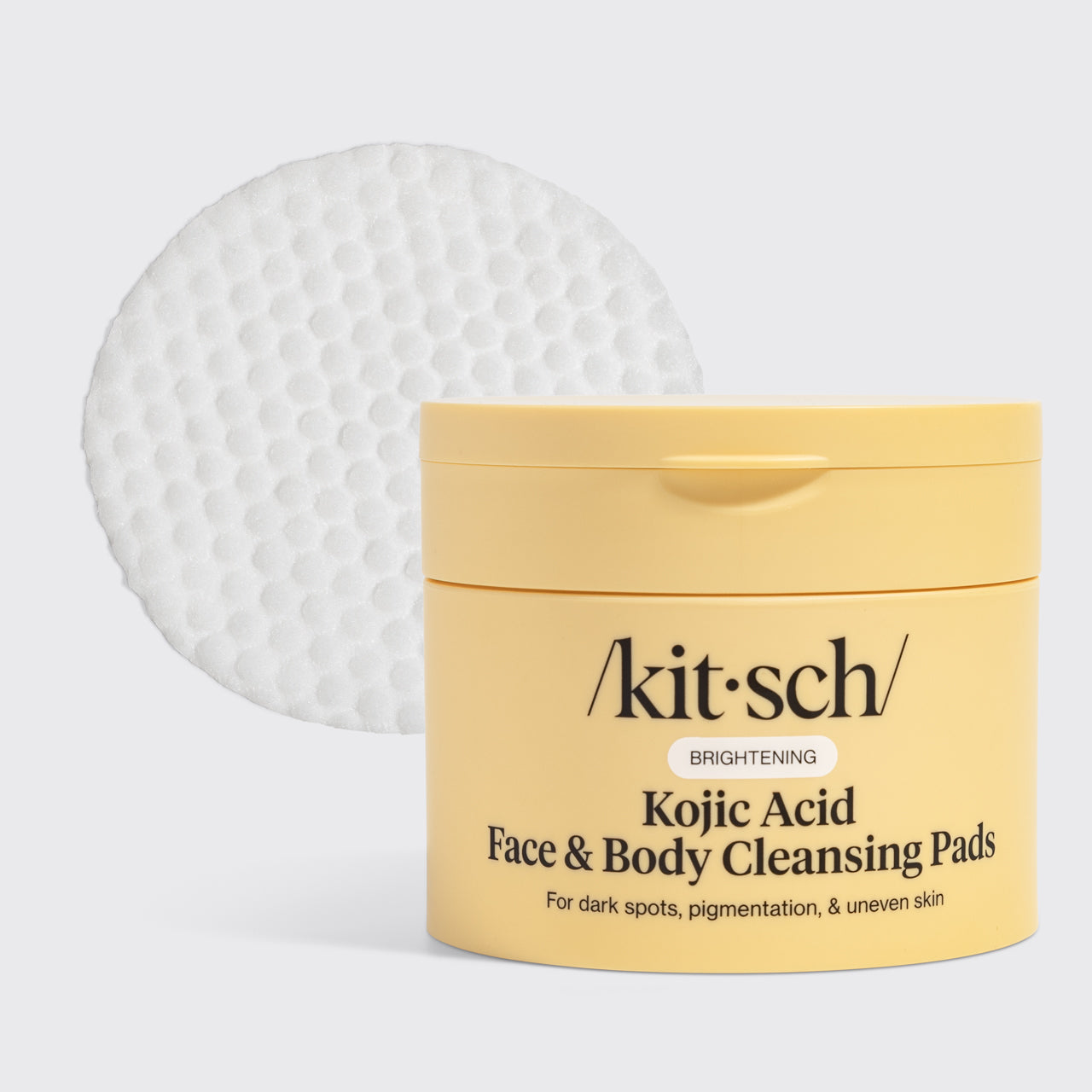 Kitsch Kojic Acid Face & Body Cleansing Pads, yellow tub with a single white pad on a light gray background, 50 pads