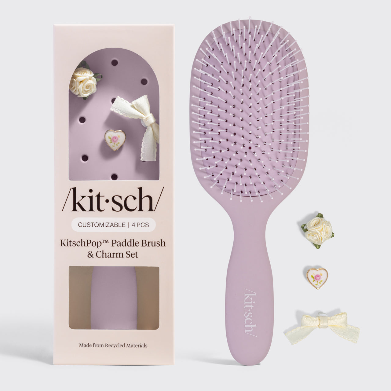 Kitsch paddle brush and charm set on a gray background