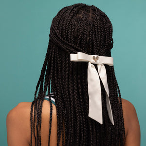 KITSCH Satin Bow Hair Clip - Cream — model wearing the cream satin bow clip in her hair — metal barrette glides in without snagging — statement accessory for a half-up or ponytail