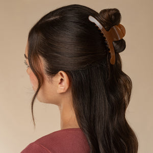 Model wearing translucent Mocha Arched Claw Clip - Large securing dark hair in a half-up hairstyle