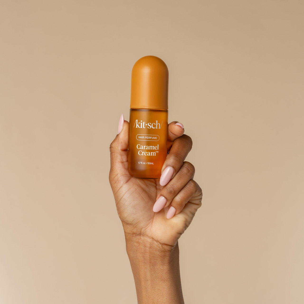 Model holding Kitsch Caramel Cream Hair & Body Perfume Mist