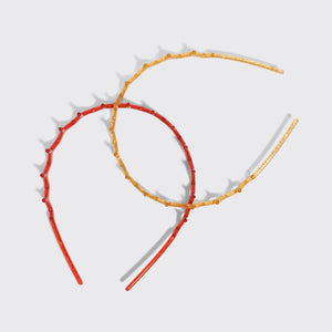 KITSCH Gold & Red Zig Zag Headbands 2pc Set — the gold and red zigzag headbands crossed on a grey background — Helps tame flyaways and loose strands — choosing between the two shades