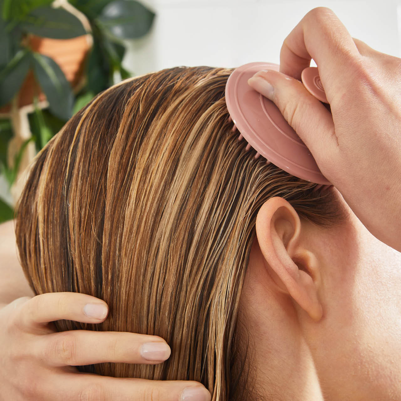Model using the Terracotta Scalp Exfoliator with Strengthening Rosemary & Biotin Scalp & Hair Oil during shower routine