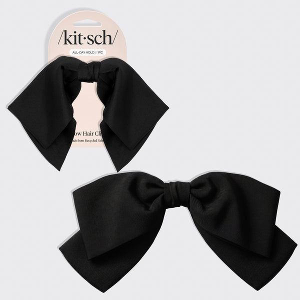 A black bow hair clip shown both on its retail backing card and as a loose product shot, on a light gray background. The brand name 'kitsch' is visible on the card.
